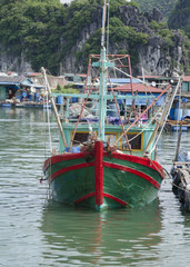 Fototapeta na wymiar Colorful fishing boat in Halong Bay in the floating village