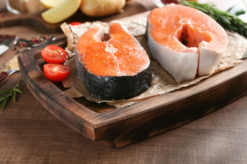 Fresh salmon steaks on wooden board