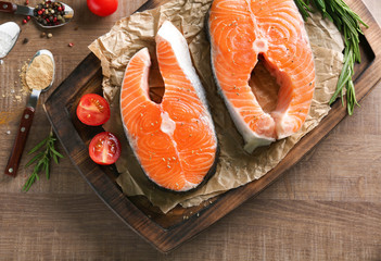 Fresh salmon steaks on wooden board