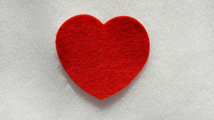 Fototapeta premium Red fabric heart on fresh white snow background