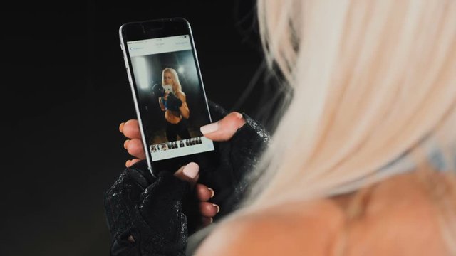 a woman looks at photos in smartphone