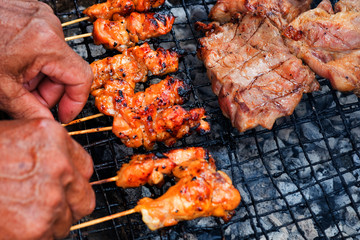 Chicken and pork grill over the small flame. shallow DOF.