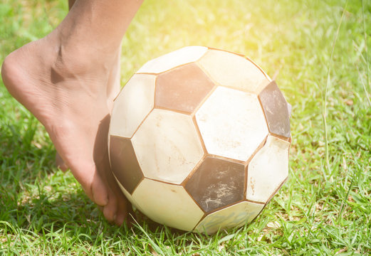 kicking soccer on the green grass.