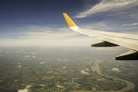 airplane wing in the sky and  top view of City landscape ,View shooting from below