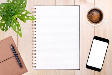 An open blank notebook, smartphone with pen and a cup of coffee on wooden table.