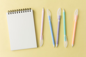 notebook with colorful pen on yellow background