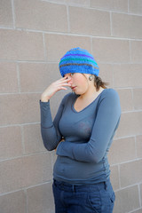 Female beauty expressions against a wall outside.