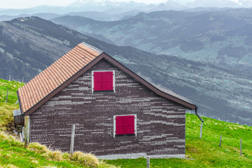 Fototapeta na wymiar wooden house on the green grass with mountain view background