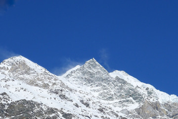 The mountains are covered with snow on blue sky in the sunny day