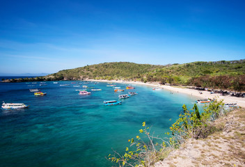Boats with tourists arriving to beautiful beach on tropical island, Lombok, Indonesia
