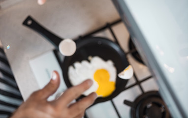 A beautiful conceptual photo with flying eggshells in a frying pan is out of focus