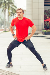 Sporty Young Man Stretching Leg Outdoors
