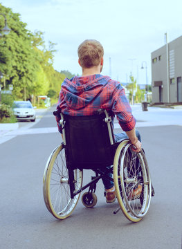disabled man in wheelchair on road