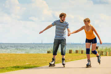 Young couple on roller skates riding outdoors