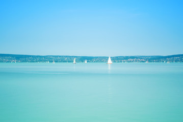 A view from a ship to bright Balaton lake water and coast at the background on sunny summer day, Hungary.