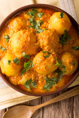 Kashmiri dum aloo: spicy potato with sauce closeup on the plate. vertical top view
