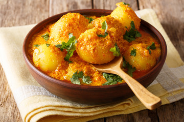 Kashmiri dum aloo: spicy potato with sauce closeup on the plate on the table. Horizontal
