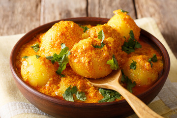 Delicious Indian Potato Dum aloo in curry sauce close-up in a bowl. horizontal