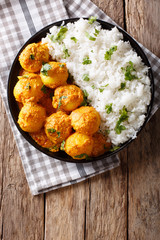 Delicious homemade Kashmiri Dum aloo potatoes with rice close-up. vertical top view