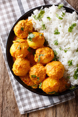 Indian food: Dum aloo potatoes in a sauce with rice close-up. vertical top view