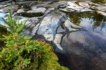 Mirror surface of water, large stones, the sky reflects