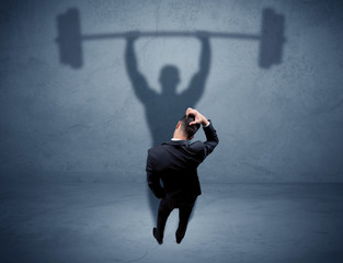 Businessman with weight lifting shadow