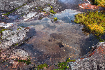Mirror surface of water, large stones, the sky reflects