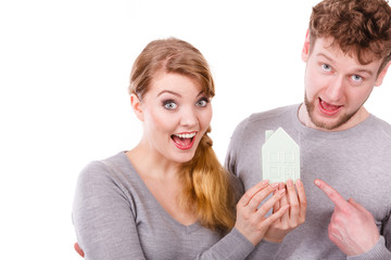 Cheerful young couple with house model.