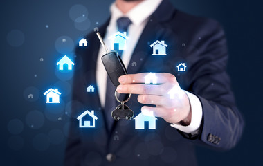 Businessman holding keys with houses around