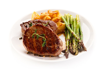 Grilled beef steaks,chips and asparagus on white background 
