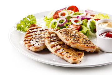 Grilled steaks and vegetable salad on white background 
