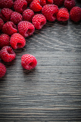 Ripe raspberries on wooden background top view