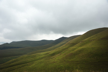 Beautiful Caucasian green landscape of the highlands with a dance of light and shadows on a hillside