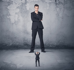 Big business bully looking at small coworker
