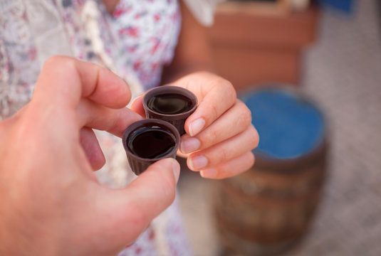 Ginja de Obidos, traditional cherry liquor of Portugal,  in the hands of tourists, close-up