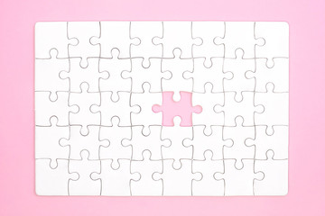 White jigsaw puzzle on pink background