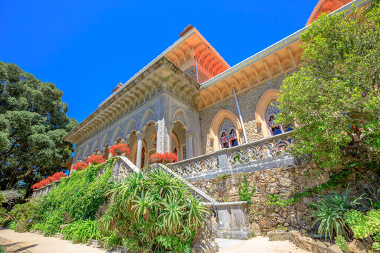 Sintra, Lisbon, Portugal. The arabesque facade of Monserrate Palace surrounded by botanical garden in beautiful sunny day. Palacio de Monserrate is the summer resort of the Portuguese court.