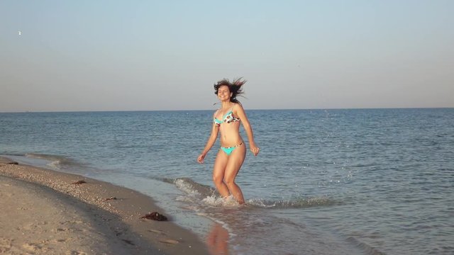 Girl on sea shoal jumps