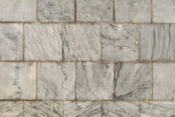 The texture of the brushed stone, marble. Different shades of gray with splotches, stripes, lines. Close-up.