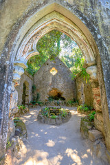 Scenic view through a window of an ancient ruins of chapel at Monserrate Park on the hills above Sintra, Portugal, Europe.