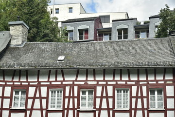Contraste entre l'architecture traditionnelle en colombages et les bâtiments modernes plus hauts dans le centre historique de Monschau au sud d'Aix-la-chapelle (Aachen) en Allemagne 
