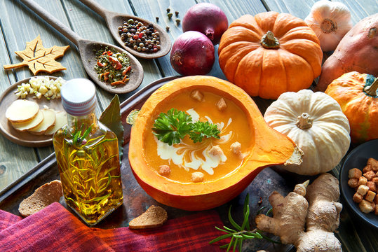 Spicy pumpkin soup served in a hollowed pumpkin with ingredients and text space