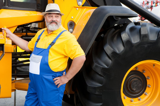 farmer in blue overalls from agricultural machinery