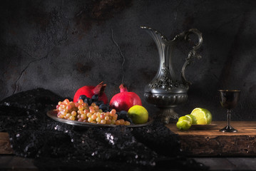 Fototapeta na wymiar Still life with fruits and wine in a metal jug