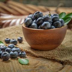 fresh bilberries or blueberries in small wooden bowls