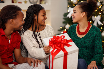 Afro-American cheerful family with gift for Christmas