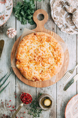 khachapuri Mingrelian with spices and herbs, on a wooden Board directly from the oven