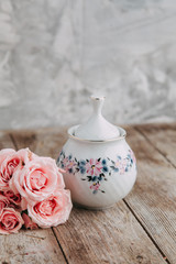 tea set in composition with flowers and marshmallows. Coffee mug on a saucer, a teapot and a sugar bowl. Filmed in the interior