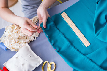 Woman tailor working on a clothing sewing stitching measuring fa