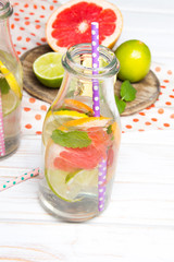 Infused flavored water with fresh fruits on white wooden background.Refreshing summer homemade  detox water
